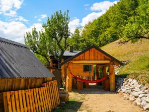 a log cabin with a red hammock in front of it at Na samote u lesa in Revúca