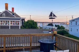 a wooden deck with a table on a house at Modern Harbor Retreat in Rockland