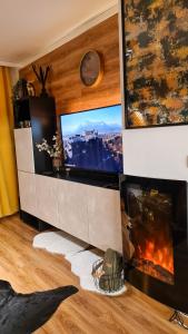 a living room with a tv and a fireplace at Apartmanica Double room apartment with balcony, St Ivan Rilski 4 star SPA Resort, Bansko in Bansko