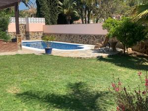 a swimming pool in a yard with a grass field at Bonito-Sol in Sitio de Calahonda