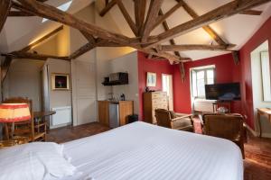 um quarto com uma cama branca e paredes vermelhas em L'hôtel de Panette, chambres indépendantes, charpente historique em Bourges