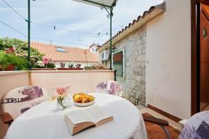- une table avec un livre et un bol de fruits dans l'établissement Apartments Ivica, à Trogir