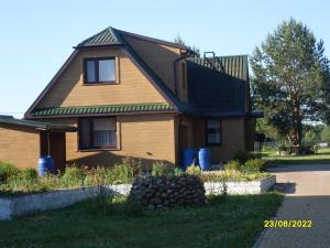 a brown house with a green roof on a street at U Heleny i Piotra pokoje goscinne in Białowieża