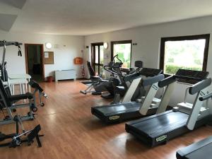 einen Fitnessraum mit Laufbändern und Heimtrainern in einem Zimmer in der Unterkunft Bed & Bike in Volterra