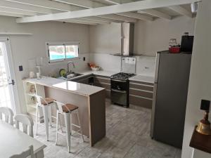 a kitchen with a refrigerator and a stove top oven at Casa de Montaña in Ciudad Lujan de Cuyo