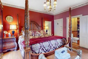 een slaapkamer met een hemelbed en rode muren bij Bridgeford House in Eureka Springs