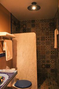 La salle de bains est pourvue d'une douche et de toilettes bleues. dans l'établissement Pousada No Meio do Mundo, à Anchieta