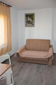 a couch sitting in a living room next to a window at Apartmani Janja in Soko Banja
