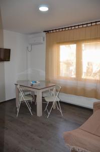 jadalnia ze stołem i krzesłami oraz oknem w obiekcie Apartmani Janja w mieście Sokobanja