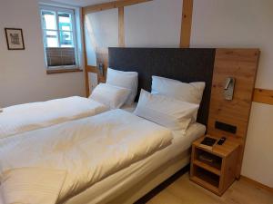 een slaapkamer met 2 bedden en een nachtkastje bij Gasthaus zum Ochsen in Mönchberg