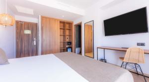 a bedroom with a bed and a desk with a television at DWO Nopal in Puerto de la Cruz
