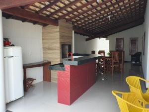 una cucina con isola rossa in una camera di Casa de praia no litoral a Luis Correia