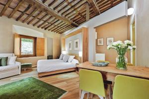 - un salon avec un lit, une table et des chaises dans l'établissement Relais Montepepe Winery & Spa, à Montignoso