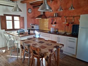 cocina con mesa, sillas y nevera en CASA ANNA, en Miravet