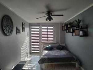 sypialnia z łóżkiem i wentylatorem sufitowym w obiekcie Apartament ul. Wczasowa 300 m od morza w Ustce