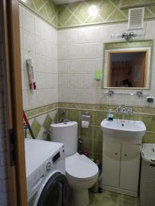 łazienka z toaletą, umywalką i pralką w obiekcie Apartament ul. Wczasowa 300 m od morza w Ustce
