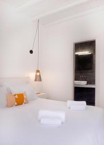 a white bedroom with a white bed and a sink at Nautilus Serifos in Livadakia