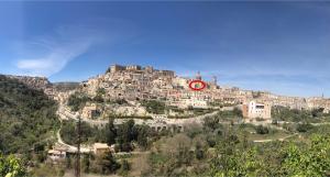 a building on top of a mountain with a red clock at Casa Alva in Ragusa