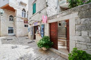 a stone building with a door and a potted plant at Apartments Ivica in Trogir