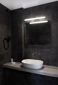a bathroom with a white sink and a mirror at Nautilus Serifos in Livadakia