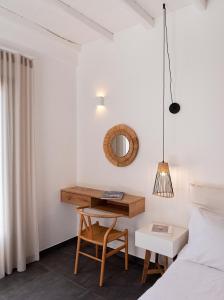 a bedroom with a desk and a bed and a mirror at Nautilus Serifos in Livadakia