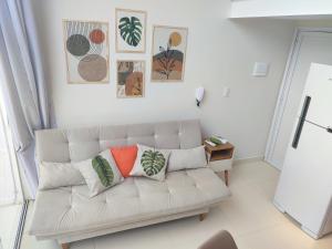 a living room with a white couch with pillows on it at Ybira Loft in Araxá