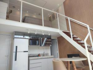 a kitchen with a spiral staircase in a loft at Ybira Loft in Araxá