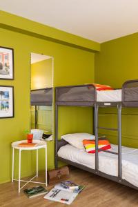 two bunk beds in a room with a green wall at Hôtel Les Hauts de Meursault in Meursault