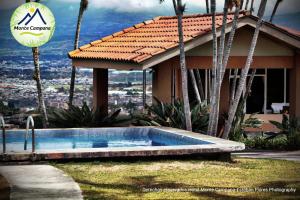 a swimming pool in front of a house at Hotel Monte Campana Escazu in San José