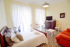 een slaapkamer met een bed, een bank en een tv bij Letmalaga Soho Apartment in Málaga