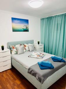 a bedroom with a bed with blue curtains at Apartament litoral in Saturn