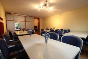 einen Konferenzraum mit Tischen, Stühlen und einer Decke in der Unterkunft Günstige Zimmer im Spessart in Mespelbrunn