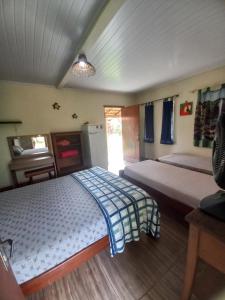 ein Schlafzimmer mit 2 Betten und einem TV in der Unterkunft Chalés Ocaso in Sao Jorge