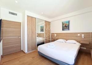a bedroom with a large white bed and a mirror at Viva Riviera - Villa Royale in Cannes