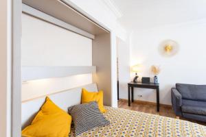 a bedroom with a bed with yellow pillows at #1 Studio Fontaine de la Ville-WIFI in Nice