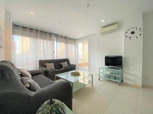 uma sala de estar com um sofá e uma televisão em Cozy apartment on the beach of Calpe em Calpe