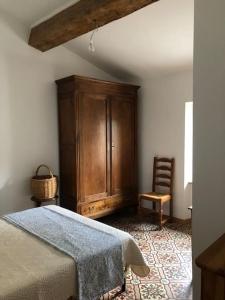 a bedroom with a bed and a wooden cabinet at appartement chez l'artiste in Minerve