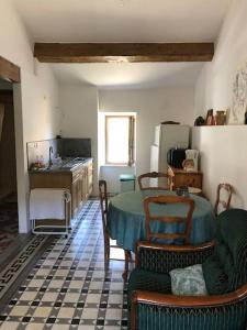 a kitchen with a table and chairs in a room at appartement chez l'artiste in Minerve