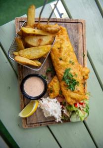 un plato de comida con pescado y patatas fritas y salsa en The Bailey bar & lounge, en Athlone