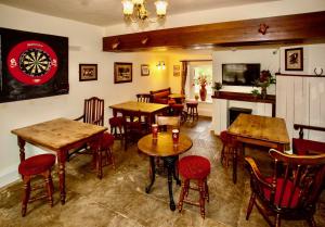 ein Restaurant mit Tischen und Stühlen und einer Dartscheibe an der Wand in der Unterkunft Sir William Hotel in Grindleford Bridge