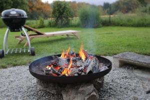 una hoguera con una parrilla en un patio en 5 Sterne FeWo mit Garten und Bergblick in Chiemsee-Nähe, en Übersee