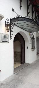 une arche avec une lampe et un panneau sur un bâtiment dans l'établissement Hotel Del Virrey, à Salta