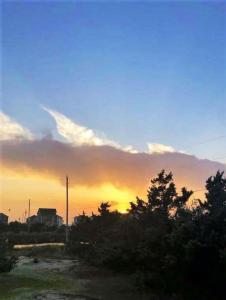 un coucher de soleil avec formation de nuages dans le ciel dans l'établissement SunSet Terrace, Avon NC, à Avon