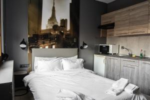 sypialnia z dużym białym łóżkiem i kuchnią w obiekcie 4 Seasons Luxury Apartments w Aleksandropolis