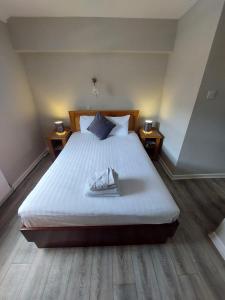 1 dormitorio con 1 cama grande y 2 mesitas de noche en The Bailey bar & lounge, en Athlone