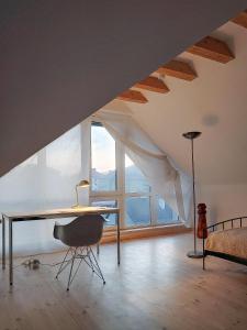 een bureau en een stoel in een kamer met een groot raam bij Apartament u Tomka Lux in Ustrzyki Dolne