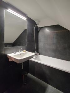 a bathroom with a sink and a tub and a mirror at Apartament u Tomka Lux in Ustrzyki Dolne