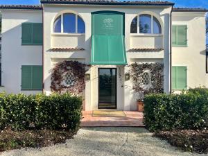 a white house with green shutters and a door at Casa tua Spa Resort in Porto Recanati