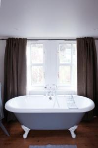bañera blanca en una habitación con 2 ventanas en Gorgeous 3 bed house in Matlock + Garden ‘lookout’ en Matlock