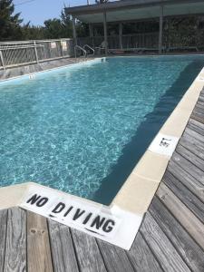 - un panneau d'interdiction de boire dans la piscine dans l'établissement SunSet Terrace, Avon NC, à Avon